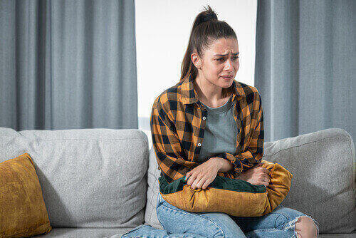 woman clenching stomach during painful withdrawal from OxyContin and alcohol